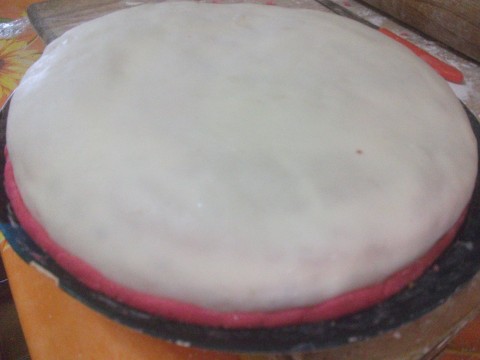 Stendiamo la pasta di zucchero bianca e ricopriamo la nostra base e cominciamo a decorare la nostra torta.