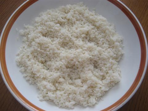 Portate a ebollizione un litro di acqua, salatela, unite il riso e cuocetelo per il tempo indicato sulla confezione. Quando è cotto scolatelo, passatelo sotto l'acqua fredda, lasciatelo sgocciolare molto bene e rovesciatelo in una ciotola. 