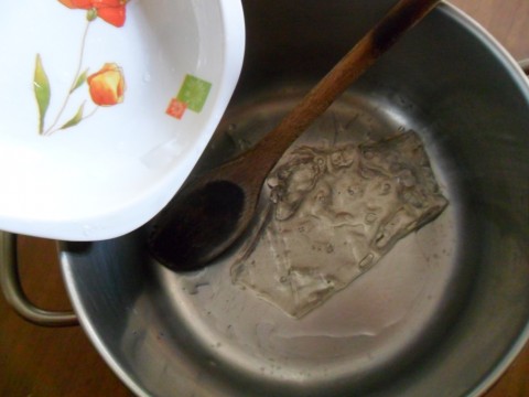 Trascorsi 10 minuti versiamo un una pentola i fogli di gelatina con l’acqua stessa (quindi non bisogna strizzarli!!), poniamo sul fuoco e mescoliamo finchè non si sarà sciolta ben bene la gelatina. IMPORTANTE: il fuoco deve essere lentissimo, usate il fornello più piccolo!