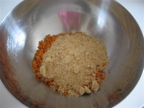 In un'ampia ciotola versare le carote e le nocciole frullate con lo zucchero