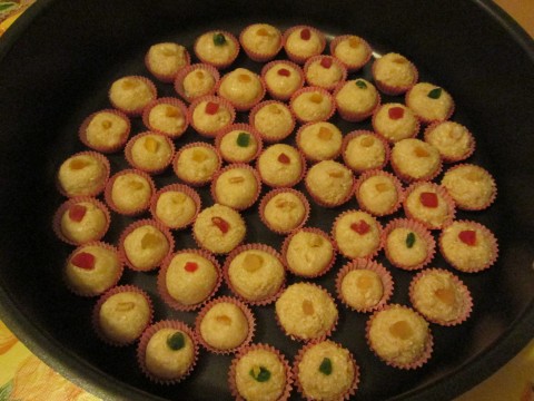 Creare delle palline e inserirle nei pirottini, aggingere sopra un pezzettino di frutta candita.