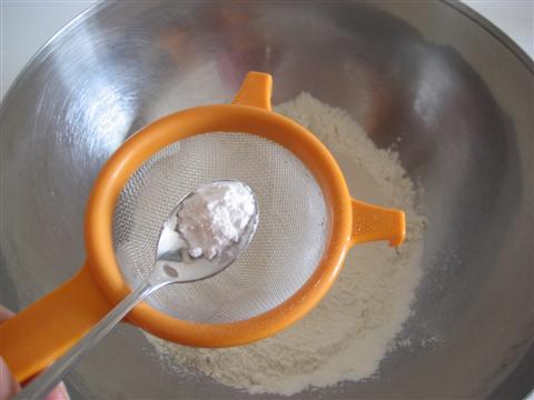 In un'ampia ciotola setacciare la farina con il lievito,