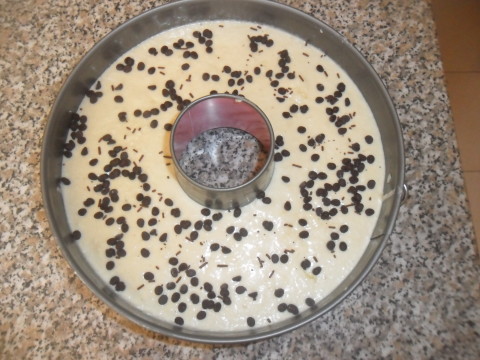 Versare il composto in uno stampo per ciambella (va bene anche per torta) imburrato. Cospargere sulla superficie della ciambella le goccie di cioccolato.