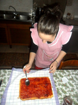 Togliere dal forno il dolce e rovesciarlo sul tavolo. Cospargere di marmellata e