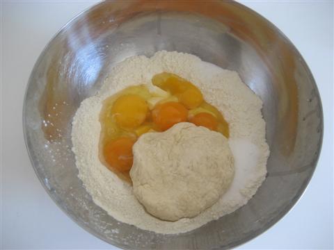 Nella stessa ciotola aggiungere la restante farina,lo zucchero, le uova, il burro morbido tagliato a pezzettini (tenuto precedentemente a temperatura ambiente), un pizzico di sale e il lievitino. 