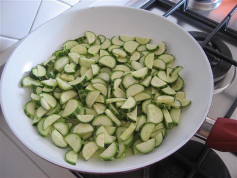 Aggiungere le zucchine lavate e tagliate precedentemente, un pò di acqua calda e cuocere a fiamma moderata con coperchio chiuso.