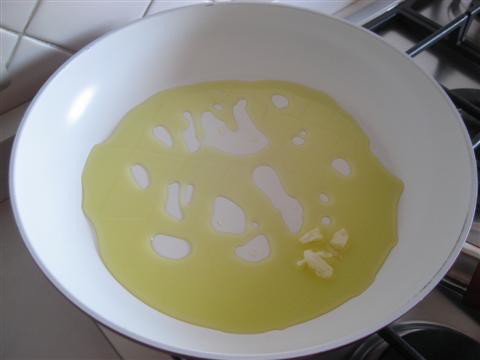 Far imbiondire l'aglio schiacciato nell'olio d'oliva, quindi eliminarlo.