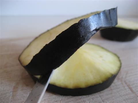 lavare la melanzana e tagliarla di uno spessore di 2 cm, tagliare ulteriormente al centro di ogni fetta in modo da creare lo spazio per poter inserire le fettine di fior di latte