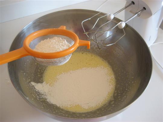 Mescolare e setacciare il lievito alla farina, aggiungerne metà al composto. 